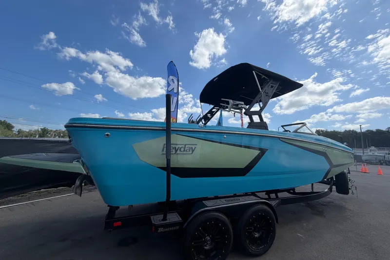 Slide: The Image of 2023 Heyday WTSurf boat in vibrant blue on trailer under a sunny sky. - 2