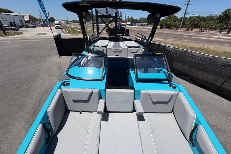 Slide: The Image of 2023 Heyday WTSurf boat with blue and white interior, parked outdoors under a clear sky. - 20