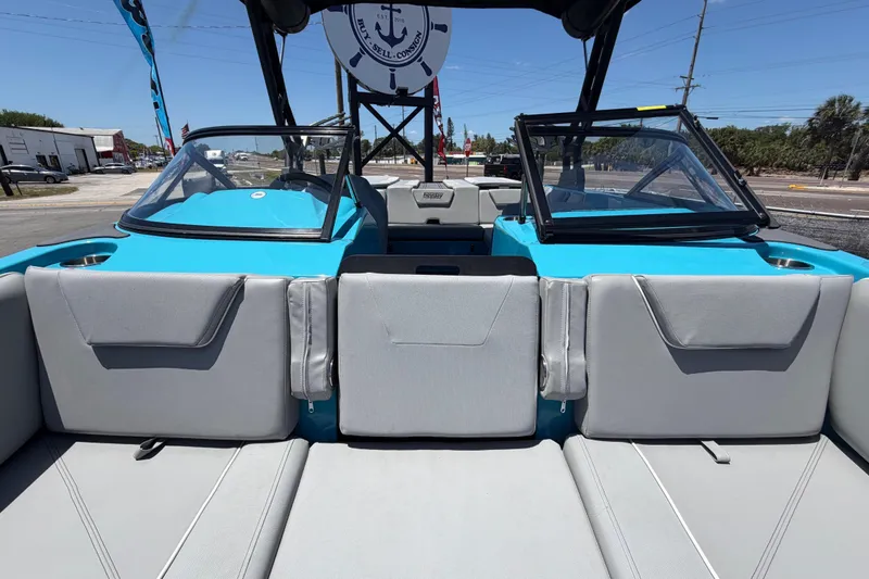 Slide: The Image of 2023 Heyday WTSurf boat with blue interior, parked outdoors under a sunny sky. - 21
