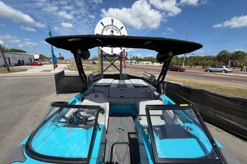Slide: The Image of 2023 Heyday WTSurf boat interior with gray seats and blue accents under a sunny sky. - 23