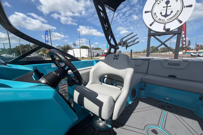 Slide: The Image of 2023 Heyday WTSurf boat interior with gray seating and wakeboard racks. - 26