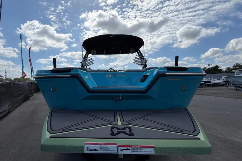 Slide: The Image of 2023 Heyday WTSurf boat, blue exterior, rear view under a partly cloudy sky. - 3