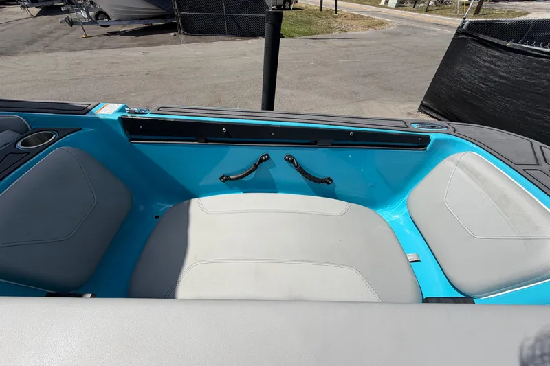 Slide: The Image of 2023 Heyday WTSurf boat interior with sun pad and seating, docked under clear skies. - 49