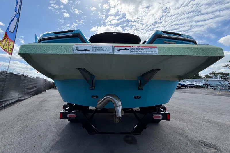 Slide: The Image of 2023 Heyday WTSurf boat rear view under a cloudy sky, showcasing its hull and exhaust. - 5