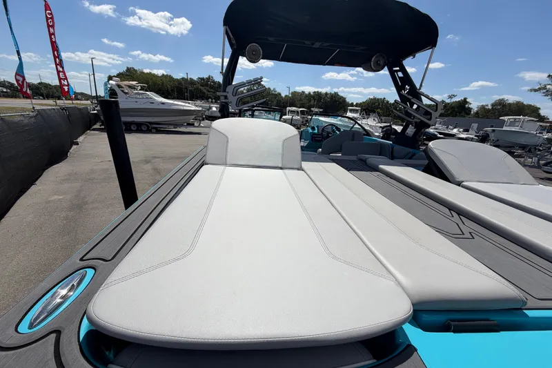 Slide: The Image of 2023 Heyday WTSurf boat interior with blue and white seating, parked outdoors. - 53