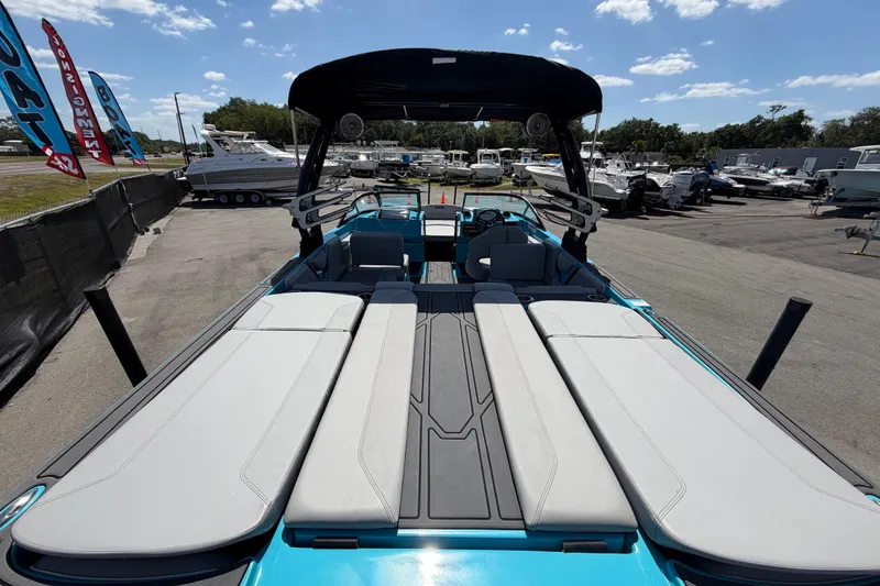 Slide: The Image of 2023 Heyday WTSurf boat interior with blue accents and seating under a sunny sky. - 56