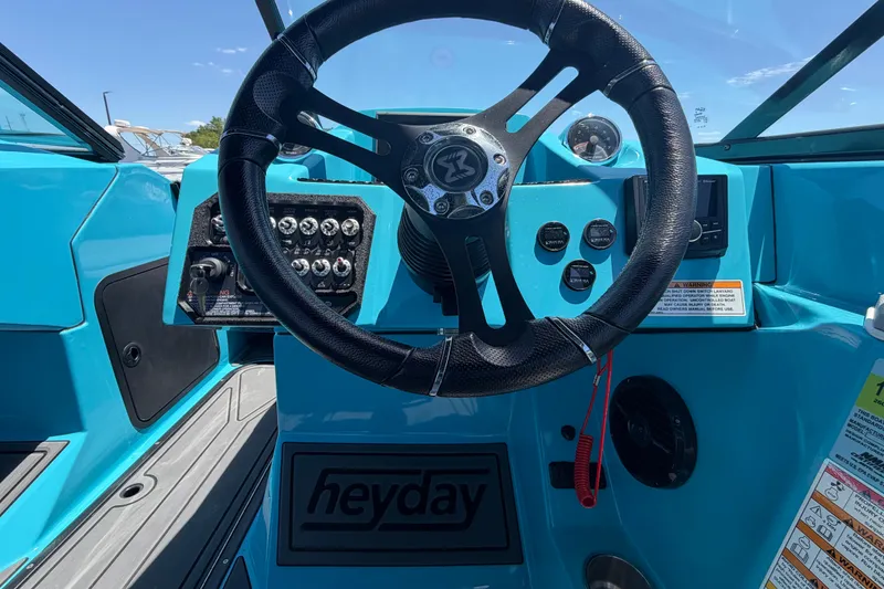 Slide: The Image of 2023 Heyday WTSurf boat dashboard with speedometer and tachometer in a marina setting. - 67