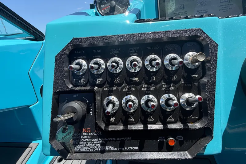 Slide: The Image of 2023 Heyday WTSurf boat interior with blue and gray seating, displayed outdoors. - 70