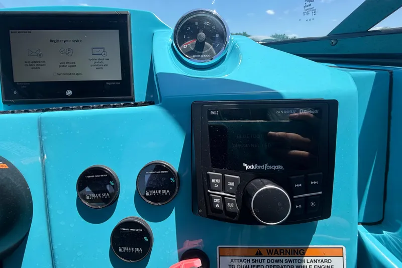 Slide: The Image of 2023 Heyday WTSurf boat interior with blue dashboard and seating at a marina. - 71