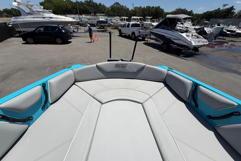 Slide: The Image of 2023 Heyday WTSurf boat interior with gray seating and armrest, displayed outdoors. - 85