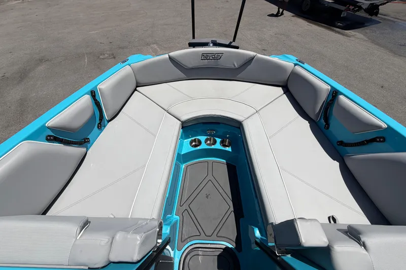 Slide: The Image of 2023 Heyday WTSurf boat interior with blue and gray seating, outdoor display. - 86