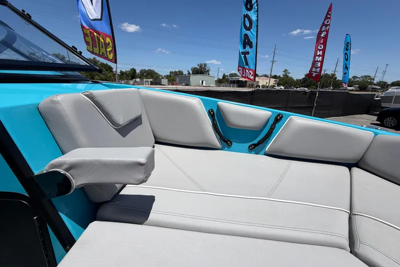 Slide: The Image of 2023 Heyday WTSurf boat interior with gray seating and turquoise accents at a marina. - 87