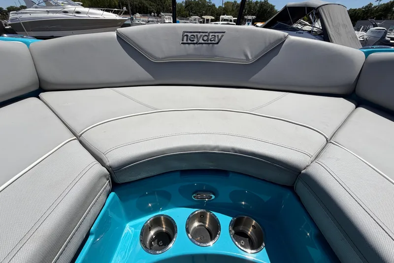 Slide: The Image of 2023 Heyday WTSurf boat interior with gray seating and blue accents. - 90