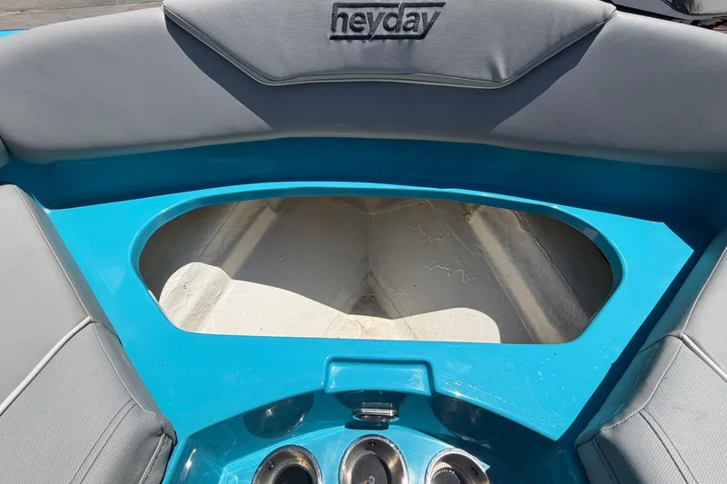Slide: The Image of 2023 Heyday WTSurf boat interior with open storage compartment, blue and gray seating. - 91