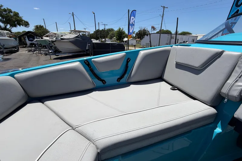 Slide: The Image of 2023 Heyday WTSurf boat interior with blue and gray seating, docked on pavement. - 92