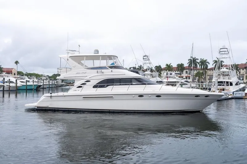 Slide: The Image of 2000 Sea Ray 560 Sedan Bridge yacht docked in a marina, surrounded by other boats. - 10