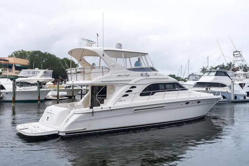 Slide: The Image of 2000 Sea Ray 560 Sedan Bridge yacht docked at marina, side view. - 11