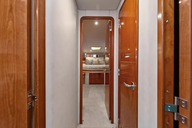 Slide: The Image of Hallway view inside 2000 Sea Ray 560 Sedan Bridge yacht, featuring wooden doors and cozy cabin. - 22