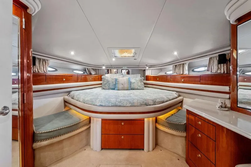 Slide: The Image of Luxurious 2000 Sea Ray 560 Sedan Bridge yacht bedroom with elegant wood finishes and plush bedding. - 23