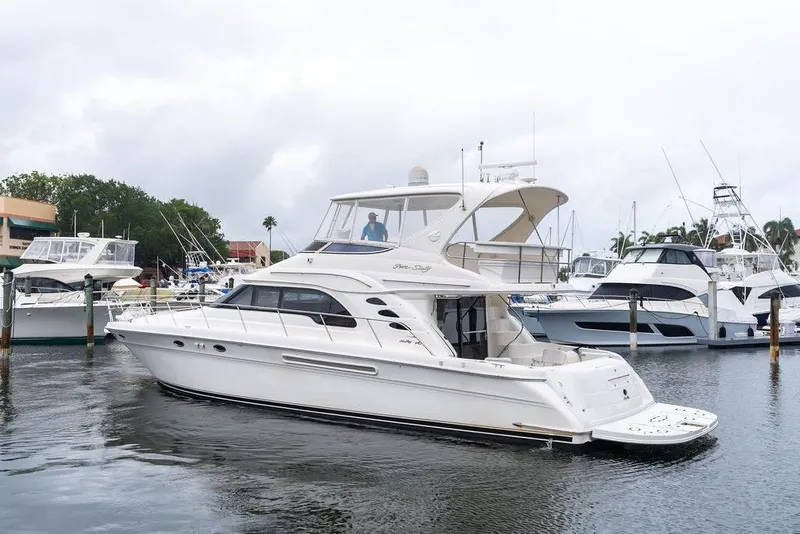 Slide: The Image of 2000 Sea Ray 560 Sedan Bridge yacht docked in a marina, surrounded by other boats. - 3
