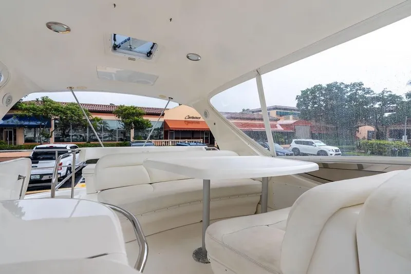 Slide: The Image of Interior view of 2000 Sea Ray 560 Sedan Bridge yacht with white seating and table. - 31