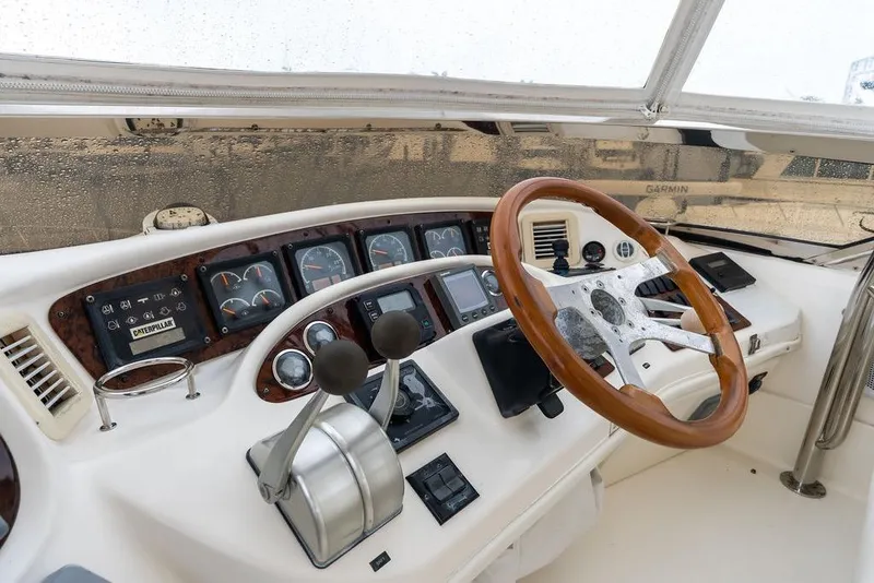 Slide: The Image of Cockpit of 2000 Sea Ray 560 Sedan Bridge with wooden steering wheel and control panel. - 37