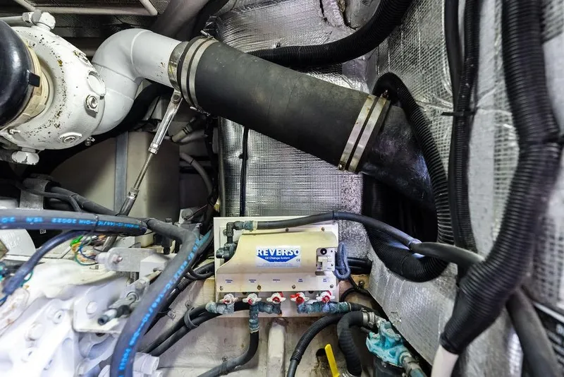 Slide: The Image of Engine room of 2000 Sea Ray 560 Sedan Bridge with hoses and mechanical components. - 47