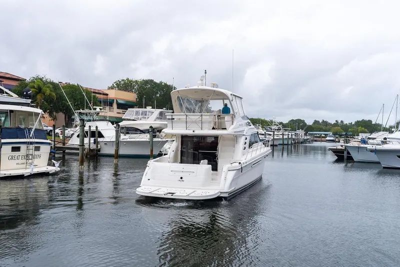 Slide: The Image of 2000 Sea Ray 560 Sedan Bridge yacht docked in a marina under cloudy skies. - 7