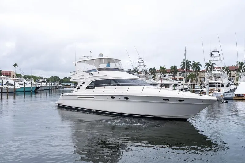 Slide: The Image of 2000 Sea Ray 560 Sedan Bridge yacht docked in a marina, surrounded by other boats. - 9