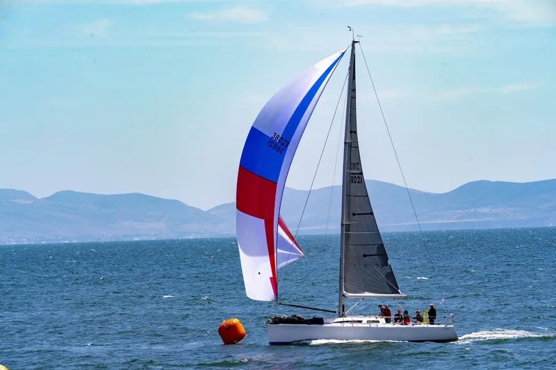Slide: The Image of Sailing yacht Sydney 38, 2000 model, with colorful spinnaker on open sea. - 2