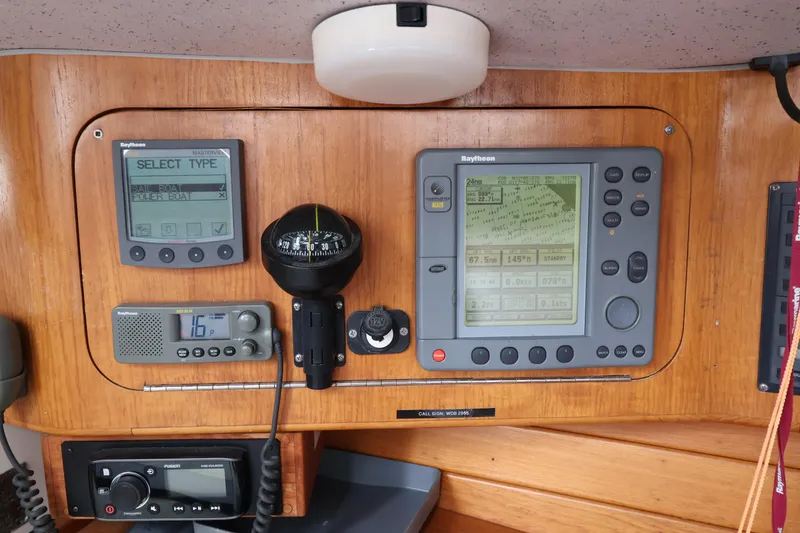 Slide: The Image of Boat navigation instruments on a Sydney 38, year 2000, featuring Raytheon displays and compass. - 23