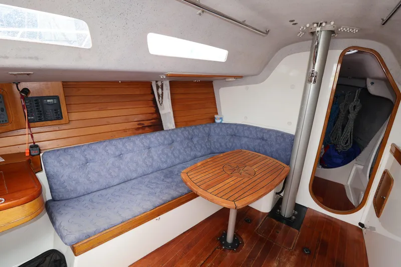 Slide: The Image of Cozy interior of a 2000 Sydney 38 sailboat with wooden table and blue seating. - 28