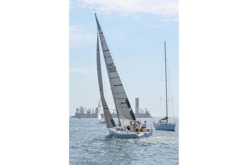 Slide: The Image of Sailboats on the ocean, featuring a 2000 Sydney 38 model under clear skies. - 3