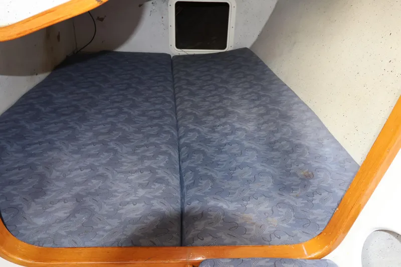 Slide: The Image of Cabin interior of a 2000 Sydney 38 sailboat with patterned blue cushions. - 33