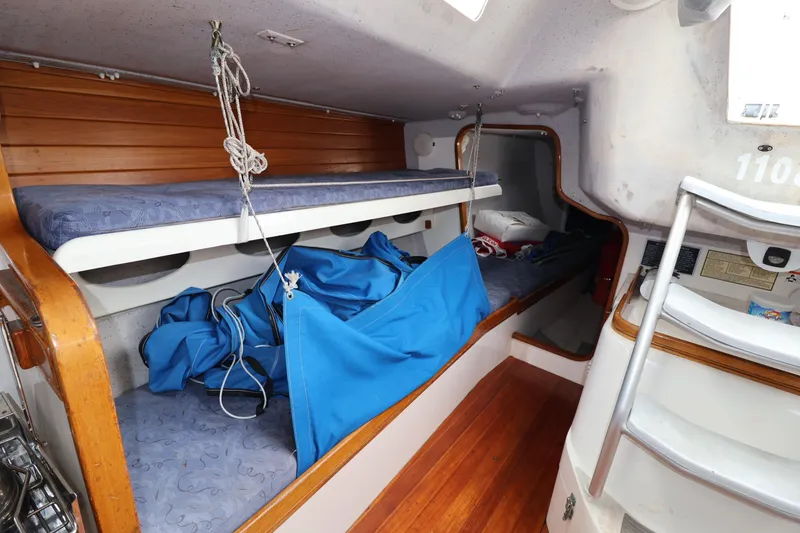 Slide: The Image of Interior of a 2000 Sydney 38 sailboat with bunk beds and wooden accents. - 35