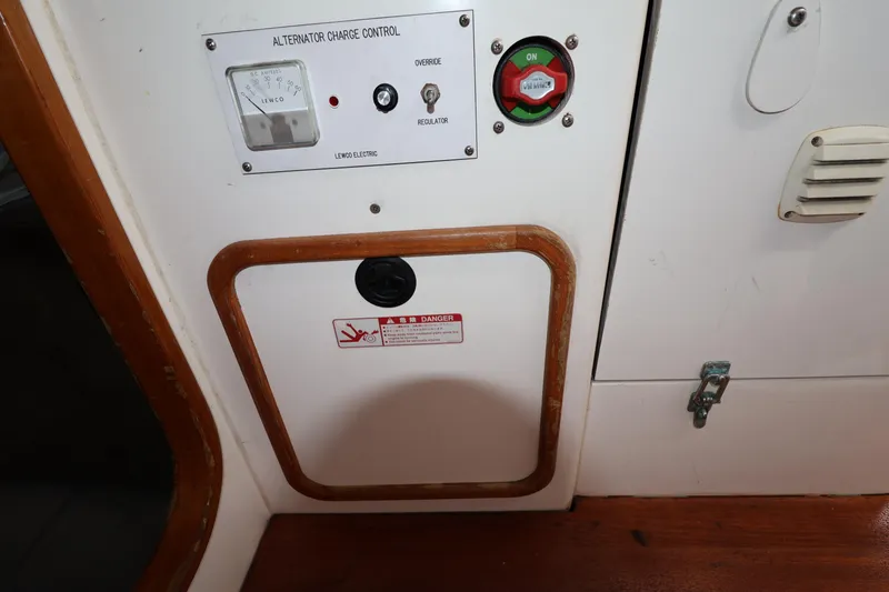Slide: The Image of Alternator charge control panel on a 2000 Sydney 38 boat, featuring switches and warning labels. - 40