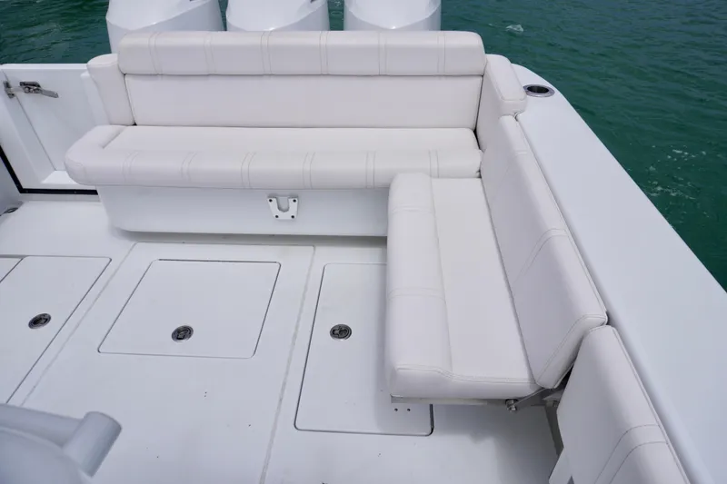 Slide: The Image of White seating area on 2013 Contender 35 LS boat, with storage compartments and ocean view. - 16
