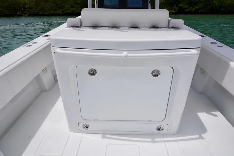 Slide: The Image of 2013 Contender 35 LS boat interior with storage compartment, white seating, and rod holders. - 19