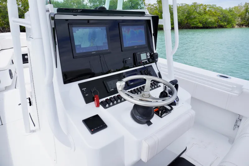 Slide: The Image of Center console of a 2013 Contender 35 LS boat with navigation screens and steering wheel. - 22