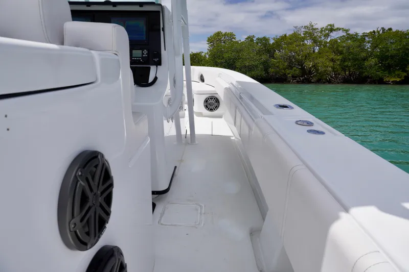 Slide: The Image of Contender 35 LS 2013 boat interior with speakers, near lush green shoreline. - 25