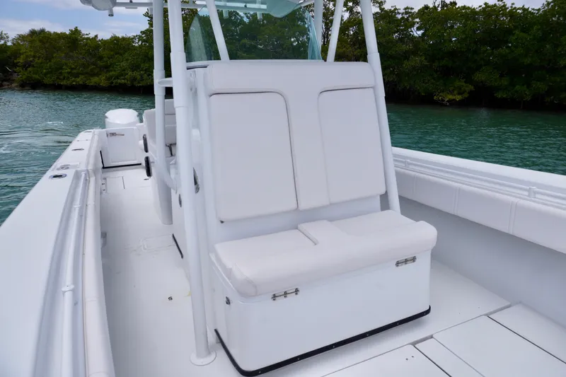 Slide: The Image of 2013 Contender 35 LS boat interior with white seating, on calm water near lush greenery. - 27