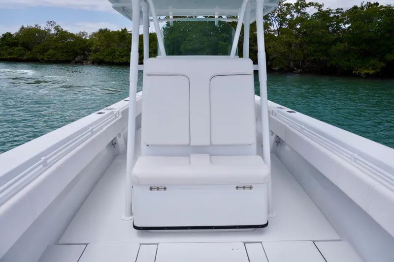 Slide: The Image of 2013 Contender 35 LS boat interior with white seating, calm water, and lush greenery. - 28