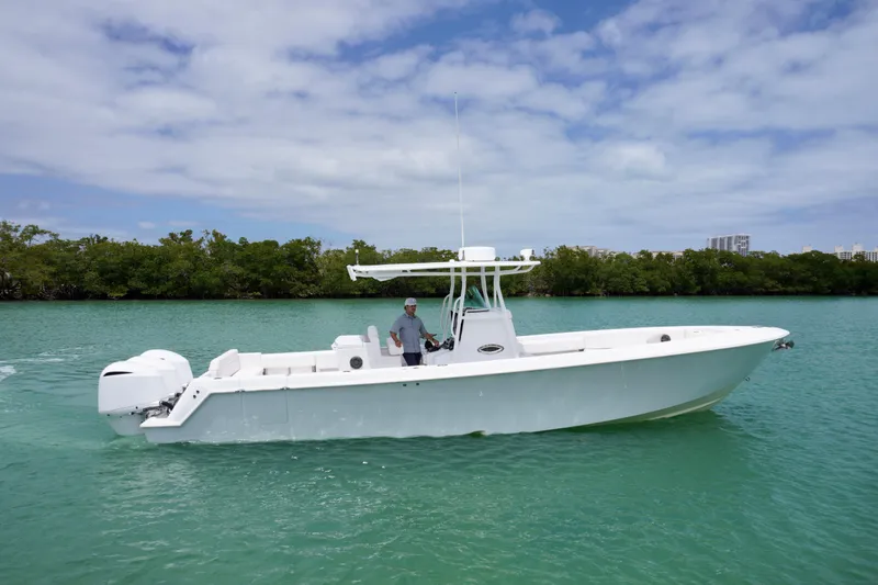 Slide: The Image of 2013 Contender 35 LS boat on turquoise water, with lush greenery in the background. - 3