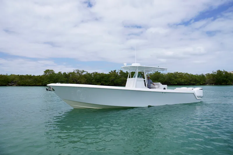 Slide: The Image of 2013 Contender 35 LS boat on calm water with lush greenery background. - 5