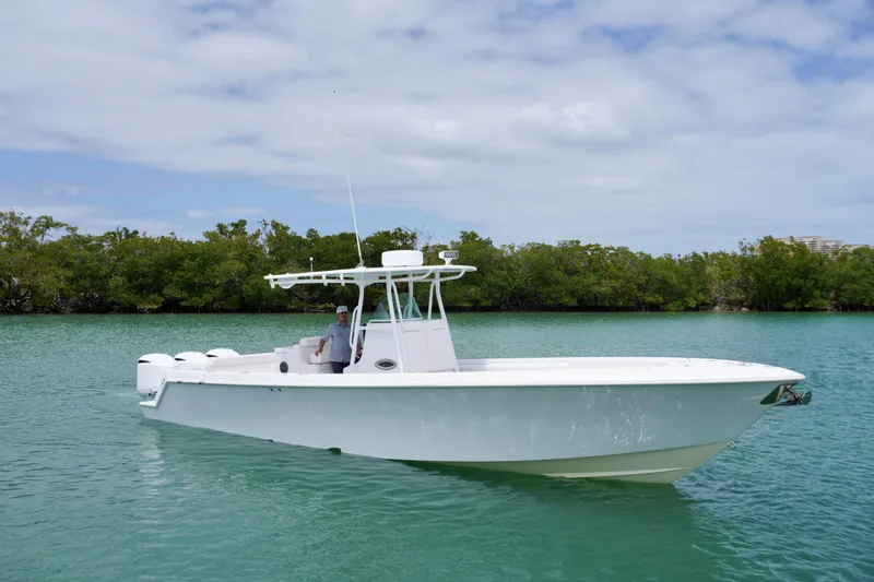 Slide: The Image of 2013 Contender 35 LS boat on calm water, surrounded by lush greenery. - 7