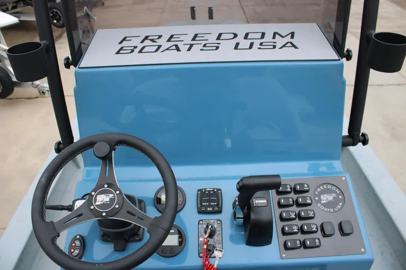 Slide: The Image of 2026 Freedom Boats 24 Defender dashboard with steering wheel and controls. - 15