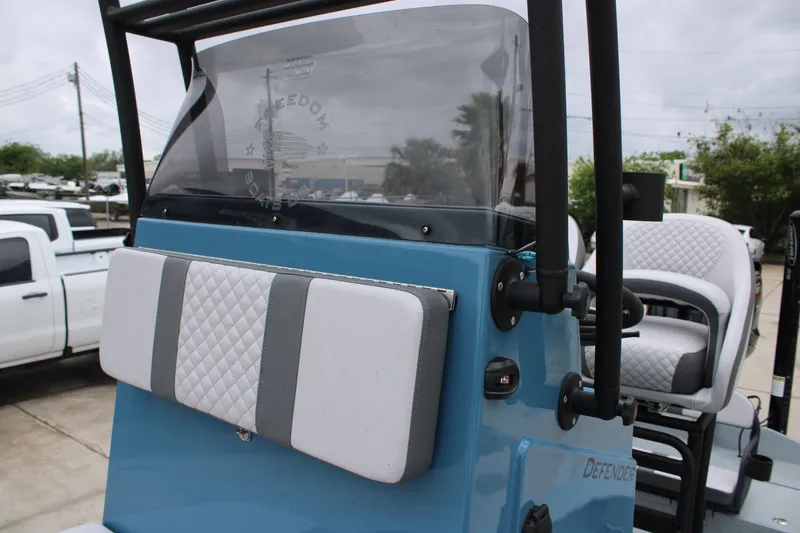 Slide: The Image of 2026 Freedom Boats 24 Defender console with cushioned seating and windshield. - 17