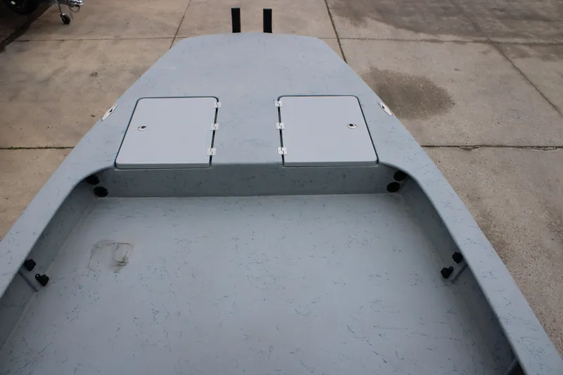 Slide: The Image of 2026 Freedom Boats 24 Defender deck with storage compartments, concrete background. - 21