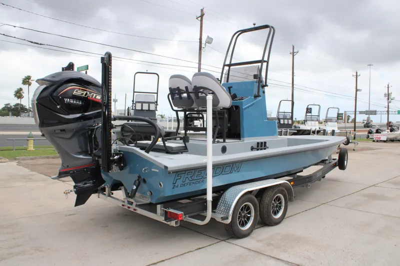 Slide: The Image of 2026 Freedom Boats 24 Defender on trailer, featuring Yamaha outboard motor, parked outdoors. - 8