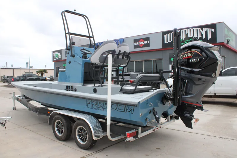 Slide: The Image of 2026 Freedom Boats 24 Defender on trailer, featuring Yamaha outboard motor, parked outside dealership. - 9